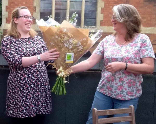 Kim receiving flowers from Kate Smith, Post-Ex Delivery Support Manager, before heading off for her maternity leave.