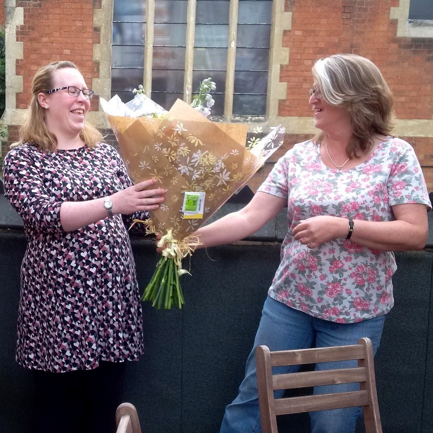 Kim receiving flowers from Kate Smith, Post-Ex Delivery Support Manager, before heading off for her maternity leave.